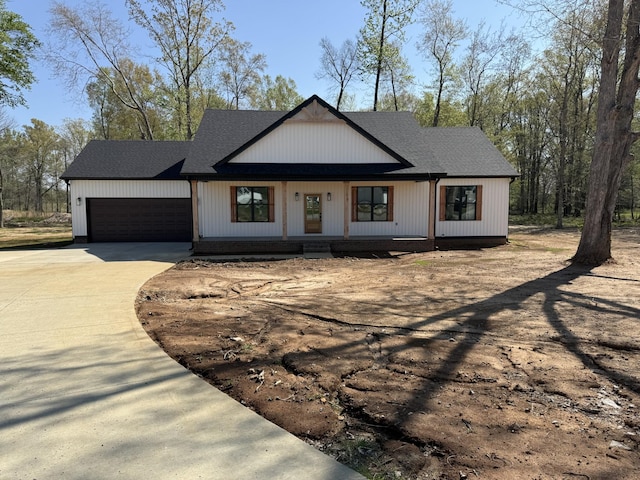 modern farmhouse featuring concrete driveway and a garage