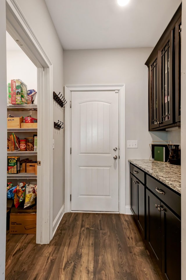 doorway to outside with dark wood-type flooring and baseboards