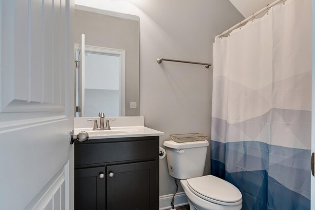 bathroom with toilet, curtained shower, and vanity