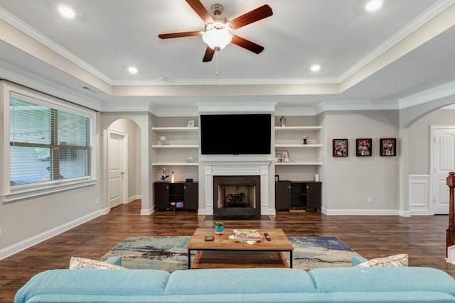 living room with a fireplace with flush hearth, arched walkways, wood finished floors, and a ceiling fan