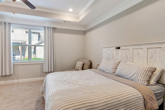 carpeted bedroom featuring baseboards, ornamental molding, recessed lighting, a ceiling fan, and a tray ceiling