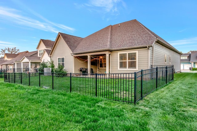 back of property featuring a patio area, a shingled roof, fence, and a lawn
