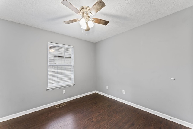 empty room featuring a textured ceiling, a ceiling fan, visible vents, wood finished floors, and baseboards