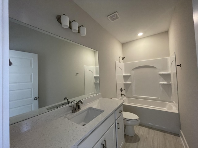 full bathroom with vanity, toilet, shower / bathtub combination, visible vents, and wood finished floors