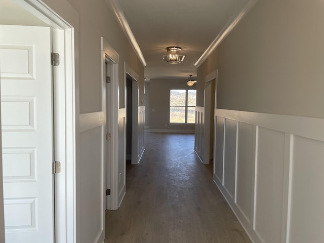 hallway featuring ornamental molding and dark wood finished floors