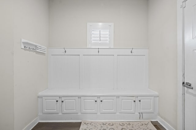 mudroom featuring a wainscoted wall, baseboards, and dark wood finished floors
