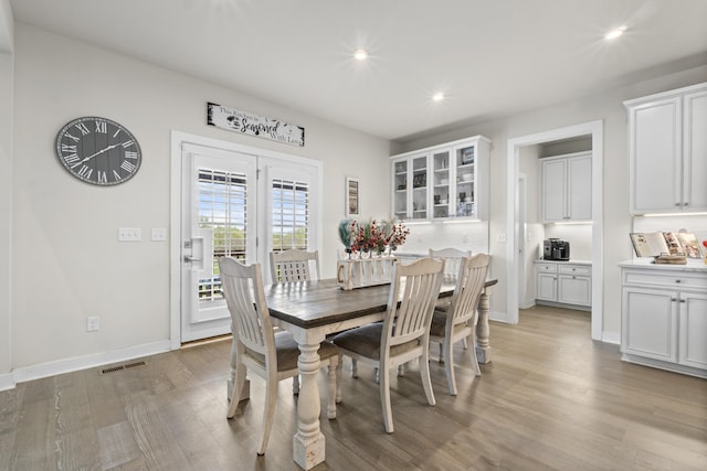 dining room featuring light wood finished floors, baseboards, visible vents, and recessed lighting