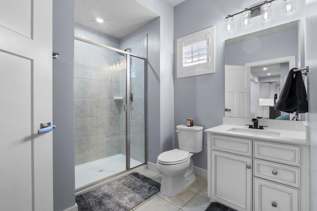 bathroom featuring vanity, baseboards, a stall shower, tile patterned floors, and toilet