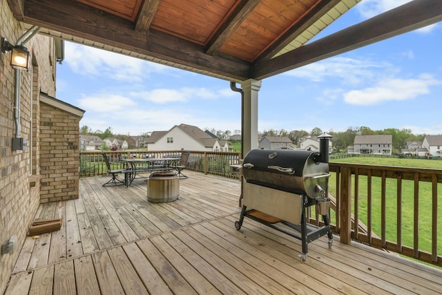 deck with area for grilling, a residential view, and a lawn
