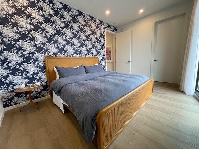 bedroom featuring wallpapered walls, light wood finished floors, baseboards, and recessed lighting