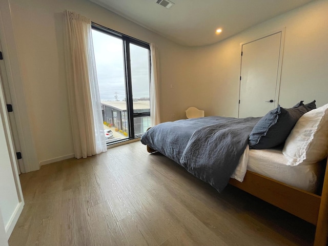 bedroom featuring light wood-type flooring, visible vents, recessed lighting, access to exterior, and baseboards