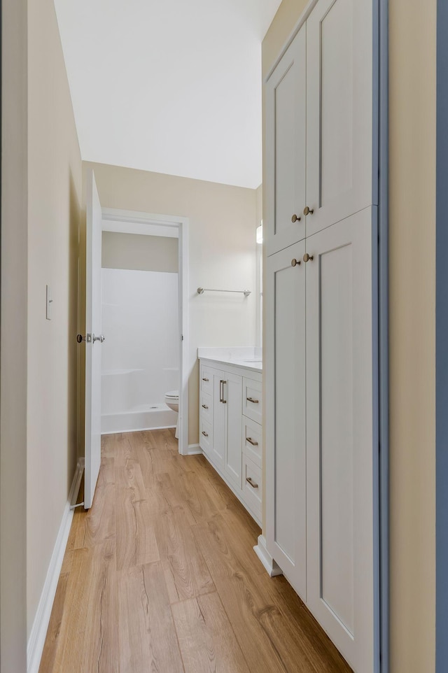 full bath featuring toilet, wood finished floors, vanity, and baseboards