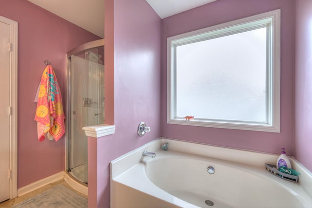 bathroom with a bath and a stall shower