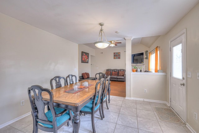 dining area featuring light tile patterned floors, baseboards, a ceiling fan, and lofted ceiling