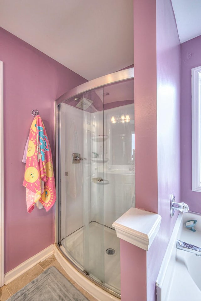 bathroom featuring a shower stall, tile patterned floors, and baseboards