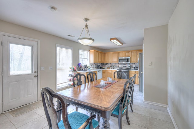 dining room with light tile patterned floors, visible vents, and baseboards