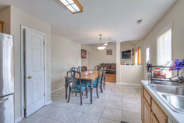 dining room with visible vents, baseboards, vaulted ceiling, and light tile patterned floors
