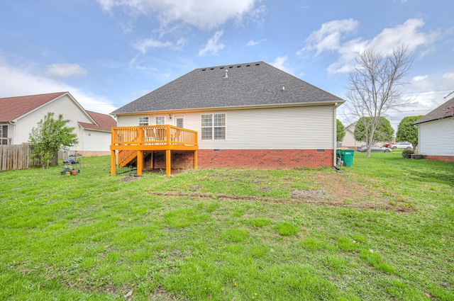 rear view of house featuring a deck, crawl space, fence, and a lawn
