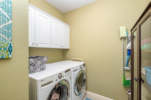 clothes washing area with washer and dryer, baseboards, and cabinet space