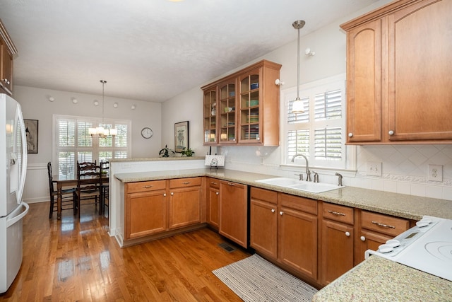 kitchen with plenty of natural light, dishwasher, a sink, a peninsula, and white refrigerator with ice dispenser