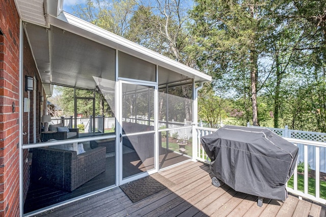 wooden terrace with a sunroom and area for grilling