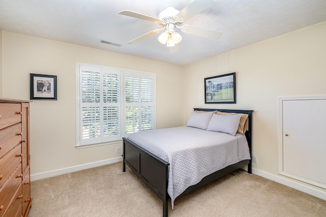 bedroom with light carpet, baseboards, a ceiling fan, and visible vents