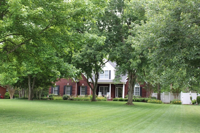 view of front of home with a front yard and fence