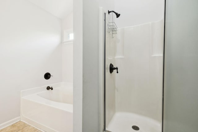 bathroom with tile patterned floors, a bath, and a stall shower