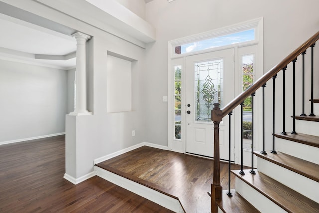 foyer with baseboards, dark wood finished floors, and stairway