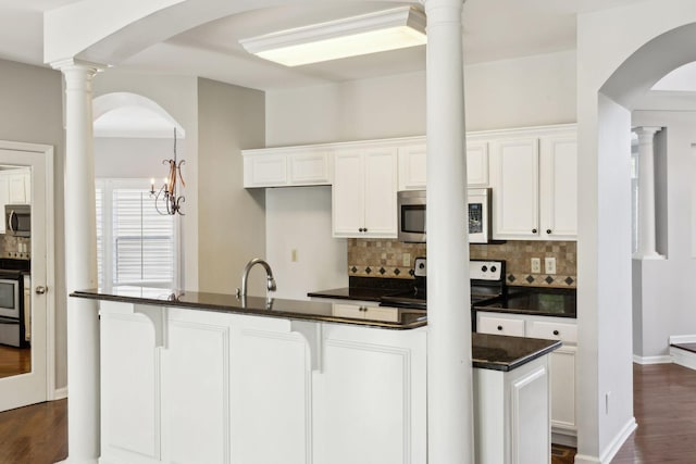 kitchen featuring tasteful backsplash, dark wood-style floors, white cabinets, and stainless steel appliances