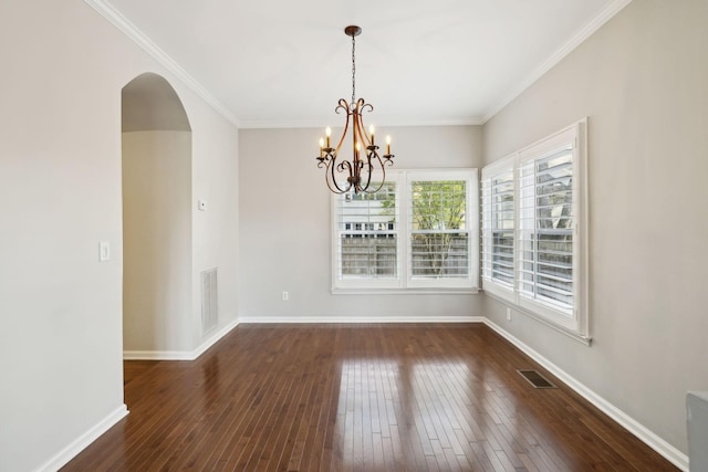 unfurnished dining area with visible vents, arched walkways, and wood-type flooring