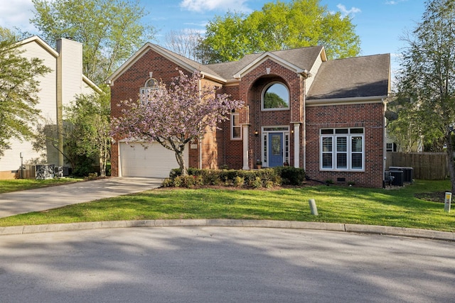 traditional-style house featuring driveway, a front yard, brick siding, a garage, and fence