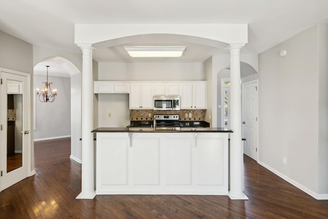 kitchen featuring white cabinetry, backsplash, dark countertops, and stainless steel appliances