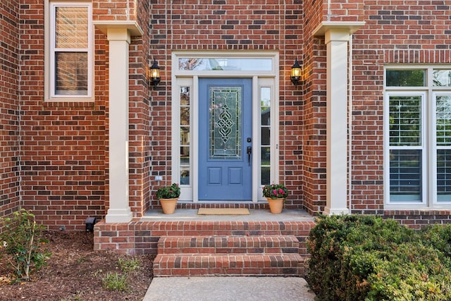 property entrance featuring brick siding