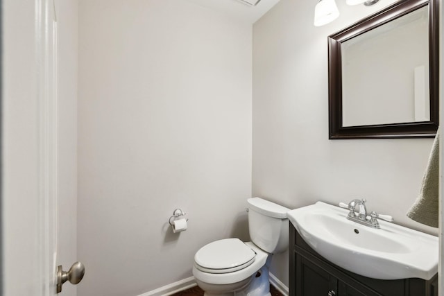 bathroom with vanity, baseboards, and toilet