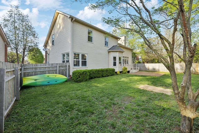 back of house featuring a patio, a fenced backyard, and a lawn