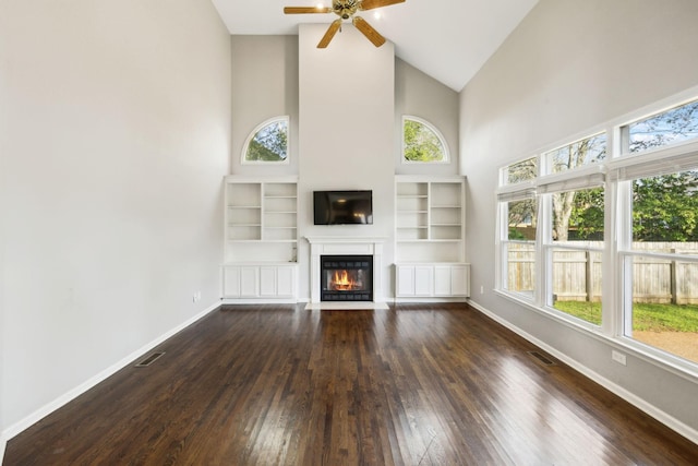 unfurnished living room with a fireplace with flush hearth, dark wood-style flooring, baseboards, and plenty of natural light