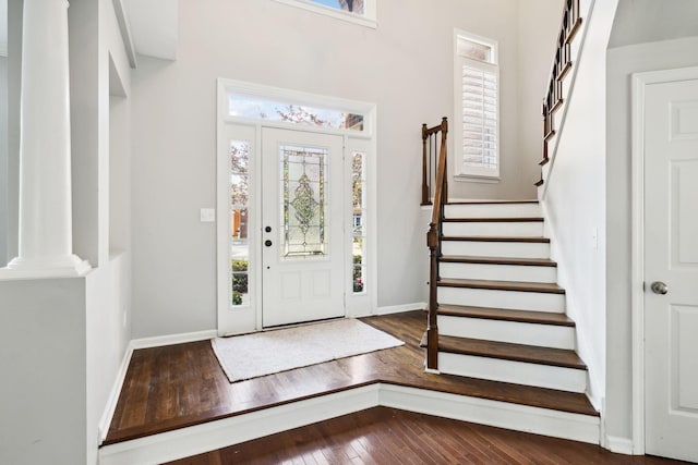 foyer featuring baseboards, stairway, and hardwood / wood-style flooring