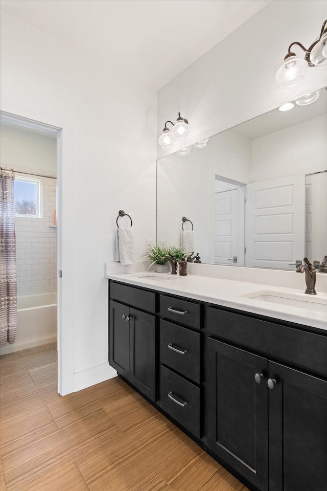 bathroom featuring baseboards, vanity, wood finished floors, and shower / bath combination with curtain