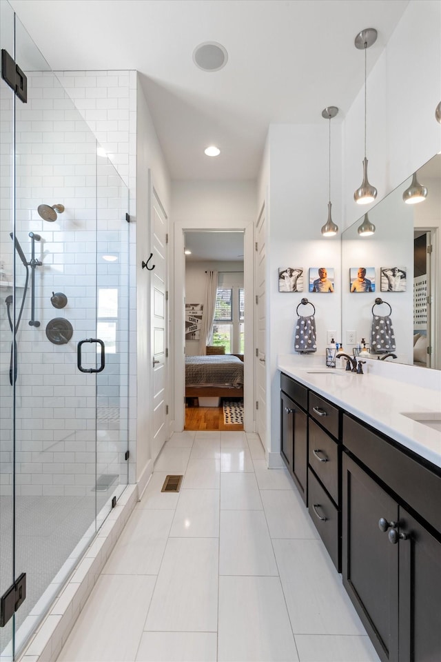 full bath with a sink, a shower stall, connected bathroom, and tile patterned flooring