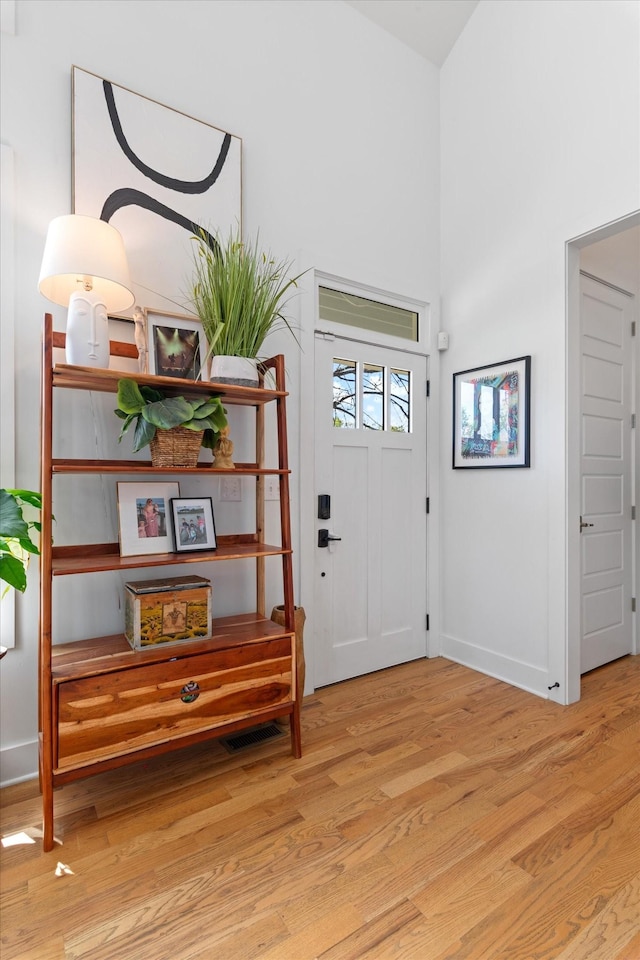 foyer featuring light wood finished floors and baseboards