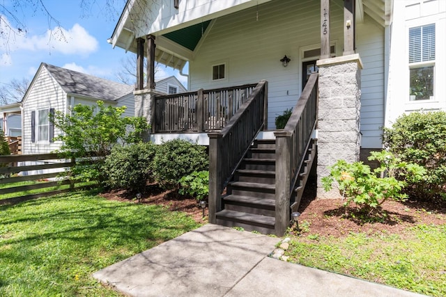 entrance to property with fence and a lawn