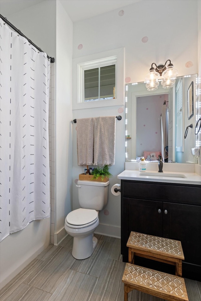 bathroom with toilet, shower / bathtub combination with curtain, vanity, and baseboards