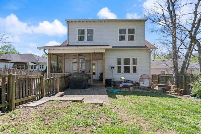 back of property featuring a sunroom, a fenced backyard, a patio area, and a lawn