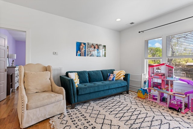 living area with visible vents, recessed lighting, and wood finished floors