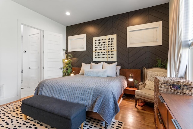bedroom featuring wood finished floors, connected bathroom, and recessed lighting