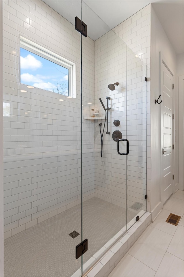 bathroom with a shower stall and tile patterned flooring