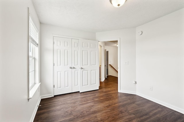 213 Nashua Ct, Murfreesboro, TN 37128 - unfurnished bedroom featuring baseboards, dark wood-style floors, a textured ceiling, and a closet