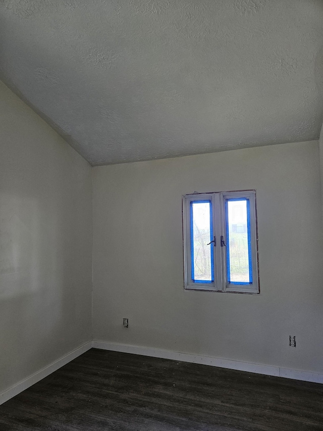 395 Church St, Spencer, TN 38585 - spare room featuring vaulted ceiling, baseboards, a textured ceiling, and dark wood finished floors