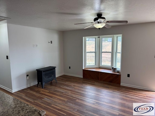 5380 Sulphur Creek Rd, Big Sandy, TN 38221 - living room with baseboards, a wood stove, a ceiling fan, a textured ceiling, and wood finished floors
